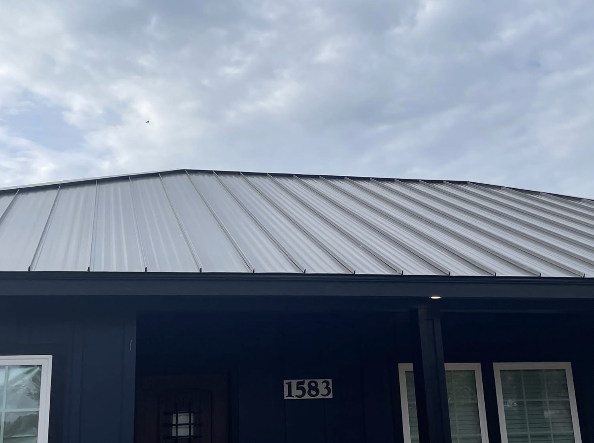 Silver ribbed metal roof on dark blue home