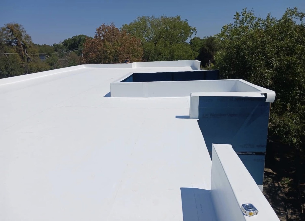 Freshly installed white TPO membrane with parapet detailing